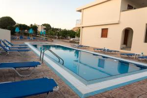 a swimming pool with blue chairs and a building at Amaryllis Beach House in Lartos +28 photos