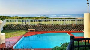 a swimming pool in a yard with a fence at Family Beach Escape: fully-equipped 6 sleeper apartment in Jeffreys Bay