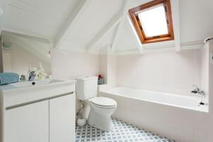 a bathroom with a toilet and a sink and a tub at Casa Primavera - renovated duplex in city centre in Funchal +18 photos