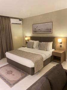 Knightsbridge Hotel & Suites في أبوجا: غرفة فندقية بسرير كبير واريكة