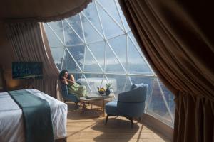 a woman sitting at a table in a room with a large window at Monticle Glamps in Vagamon +35 photos