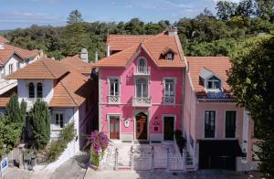 una casa rosa en una fila de casas en Sintra Marmòris Camélia, en Sintra