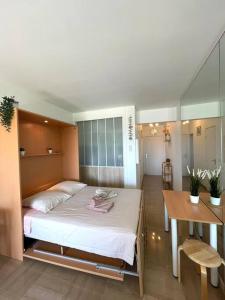1 dormitorio con 1 cama grande y 1 mesa en Studio Port Marina, en Villeneuve-Loubet