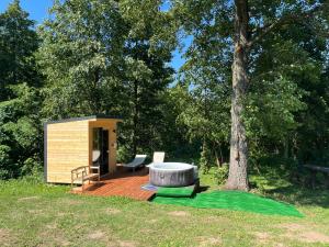 a small cabin on a wooden deck next to a tree at Holiday Home na Mazurach nad Jeziorem in Regiel