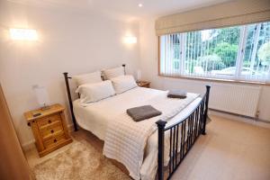 a bedroom with a bed and a large window at Luxury property - Swimming Pool, Games Room & Hot Tub in Usk