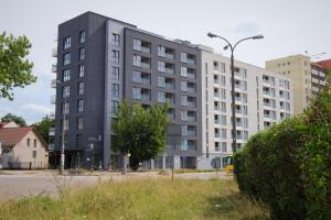 un bâtiment gris avec un éclairage de rue devant lui dans l'établissement Apartamenty Centrum, à Białystok