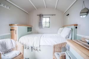 a small bedroom with a bed in a room at Haven View - 1 Bedroom Shepherds Hut - St Ishmaels in Saint Ishmaels