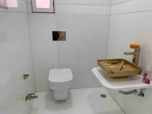 a white bathroom with a toilet and a sink at Luxury 3BHK Aprtmnt City View Balcony HSpeed Wifi Free Parking in Kolkata