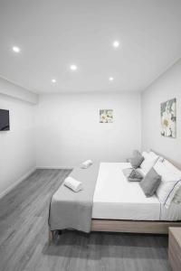 um quarto branco com uma cama grande e paredes brancas em Capodichino Apartment 127 - 20 em Nápoles
