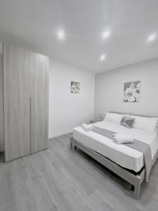 um quarto branco com uma cama grande e um armário em Capodichino Apartment 127 - 20 em Nápoles