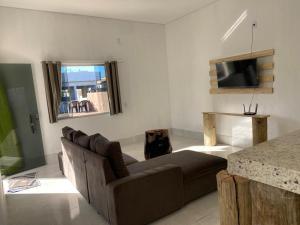 sala de estar con sofá y TV en Casa de Praia do Marcinho en Prado