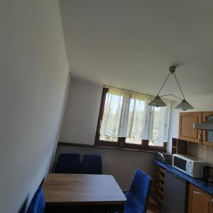eine Küche mit einem Tisch und Stühlen im Zimmer in der Unterkunft Mieszkanie z balkonem in Głuszyca