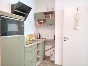 La cuisine est équipée d'un réfrigérateur vert et d'un évier. dans l'établissement Ferienzimmer Seepark, à Vienne