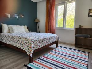 a bedroom with a bed and a window and a rug at ADRASAN TATİL EVLERİ 1 in Adrasan