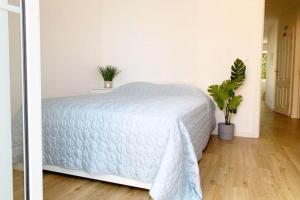 1 dormitorio con 1 cama con colcha blanca en Apartment Primavera: City centre, modern w/balcony en Funchal