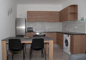 a kitchen with a table and chairs and a refrigerator at Cerviola Etrin Court in Marsaskala