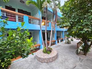 a blue building with palm trees in front of it at Ocean View Resort in Ko Tao +206 photos