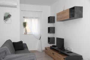 a living room with a couch and a tv at Cerviola Etrin Court in Marsaskala
