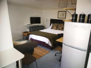 a bedroom with a bed and a desk and a television at Loveable Karoo Cottages in Fraserburg