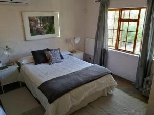 a bedroom with a large bed and a window at Loveable Karoo Cottages in Fraserburg