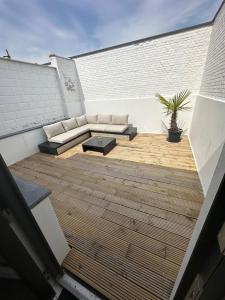 a patio with a couch and a table on a building at Antwerp West Side, TERRACE in Zwijndrecht