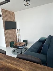 a living room with a blue couch and a table at Antwerp West Side, TERRACE in Zwijndrecht