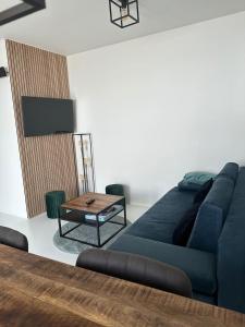 sala de estar con sofá azul y mesa en Antwerp West Side, TERRACE, en Zwijndrecht