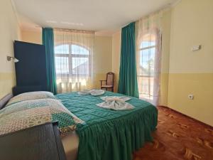 a bedroom with a bed with a green bedspread at Villa Lira in Hévíz