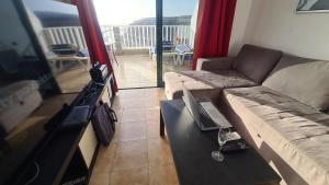 a living room with a couch and a laptop on a table at Puerto Rico Top Teide and Amadores View in Puerto Rico de Gran Canaria