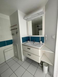 a white bathroom with a sink and a mirror at Entre bassin et forêt in La Teste-de-Buch
