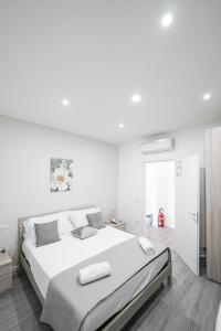 um quarto branco com uma cama grande e 2 almofadas em Capodichino Apartment 127 - 20 em Nápoles