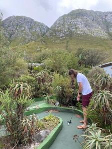 a woman is playing golf on a golf course at Oceanscape in Bettyʼs Bay
