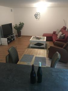 una sala de estar con una mesa con dos botellas. en Peter's Ferienwohnung im Souterrain, en Neuried