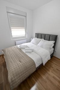 Schlafzimmer mit einem großen Bett und einem Fenster in der Unterkunft Porto lux in Aranđelovac