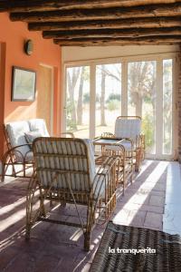 a porch with chairs and a table and windows at Finca La Tranquerita in San Rafael