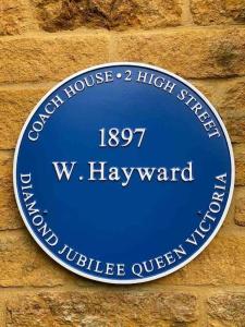 une plaque bleue sur un mur de briques dans l'établissement Historic Cotswold Chic Style for UK staycation, à Bourton-on-the-Water