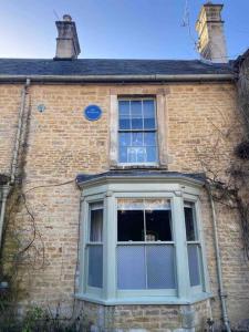 - un bâtiment en briques avec une grande fenêtre dans l'établissement Historic Cotswold Chic Style for UK staycation, à Bourton-on-the-Water