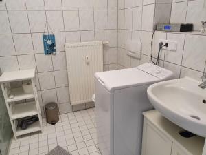 a white bathroom with a sink and a washing machine at Ferienwohnung direkt am Kurpark Laga mit Gradierwerk Solestadt in Bad Dürrenberg