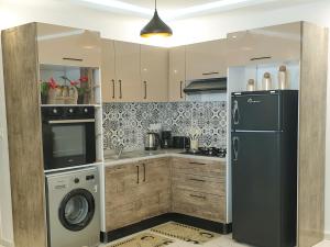 a kitchen with a refrigerator and a washer and dryer at Cosy House La Marsa in Tunis