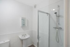 a white bathroom with a sink and a shower at Warm & Inviting 4-Bed on Church Road, Sleeps 4 in Stockton-on-Tees