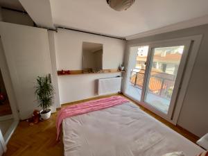 a bedroom with a bed and a large window at Central Izmir Delight: Cozy Alsancak Apartment in Konak