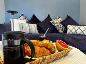 uma bandeja de croissants e frutas numa mesa em GREAT LOCATION! 4 bed house with garden & parking - Parkstone House em Parkstone