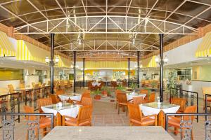een restaurant met tafels en stoelen en een cafetaria bij Evoma in Bangalore