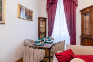 a dining room with a table and chairs in front of a window at Domus Quirinale in Rome
