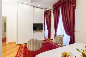 a living room with red curtains and a table and chairs at Domus Quirinale in Rome
