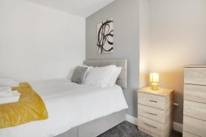 a white bedroom with a bed and a night stand at Stylish Comfort 2-BedFlat In Stockton, Sleeps 3 in Stockton-on-Tees