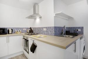 a kitchen with white cabinets and a sink at Stylish Comfort 2-BedFlat In Stockton, Sleeps 3 in Stockton-on-Tees