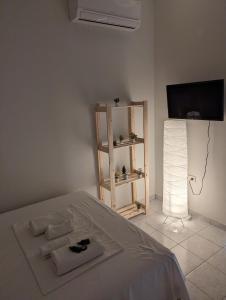 a bedroom with a bed and a tv and a lamp at Saranda Landscape in Sarandë