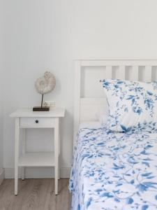 a bedroom with a bed and a nightstand with a blue and white bedspread at Marejada Coastal Suite in Puertito de Güímar
