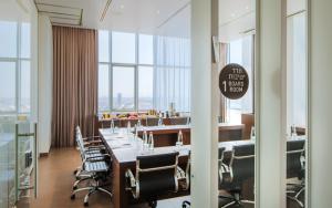 une salle de conférence avec une grande table et des chaises dans l'établissement Prima Link Hotel, à Petaẖ Tiqwa